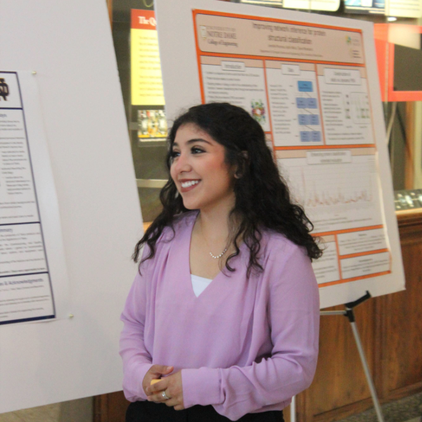 A student smiles near her poster at Galvin Scholars Poster Session 2023