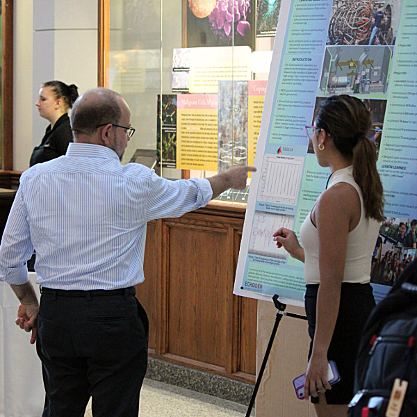 Dan Gezelter, a professor of Chemistry and Biochemistry and associate dean for Undergraduate Studies in College of Science, talks to a student about their poster during Galvin Scholars Poster Session 2023