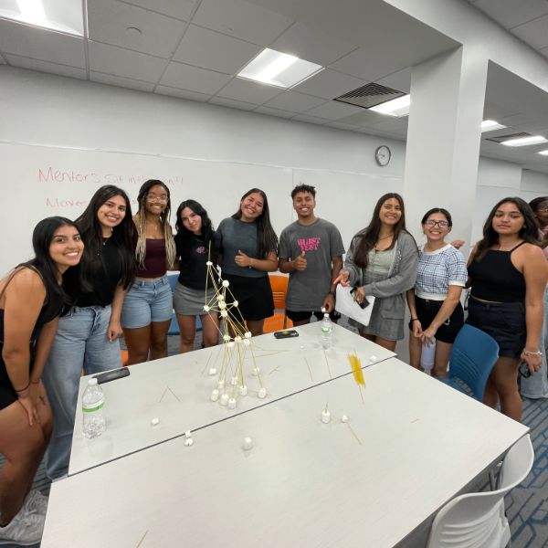 A group of students gather around a table to pose together at Galvin Scholars Mentor Mentee Meeting 2023