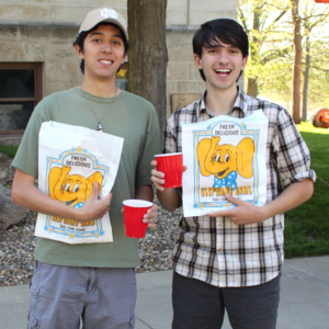 Two students pose with their elephant ears and lemonade takeout bags at Galvin Scholars Year-End Event