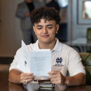 2024 Galvin Scholar Senior Brunch student reading the program book